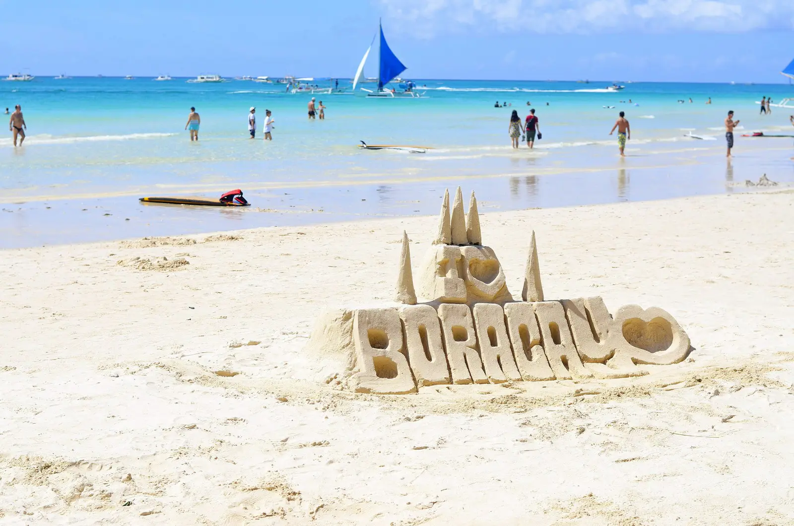 People walking along Boracay beach in the Philippines